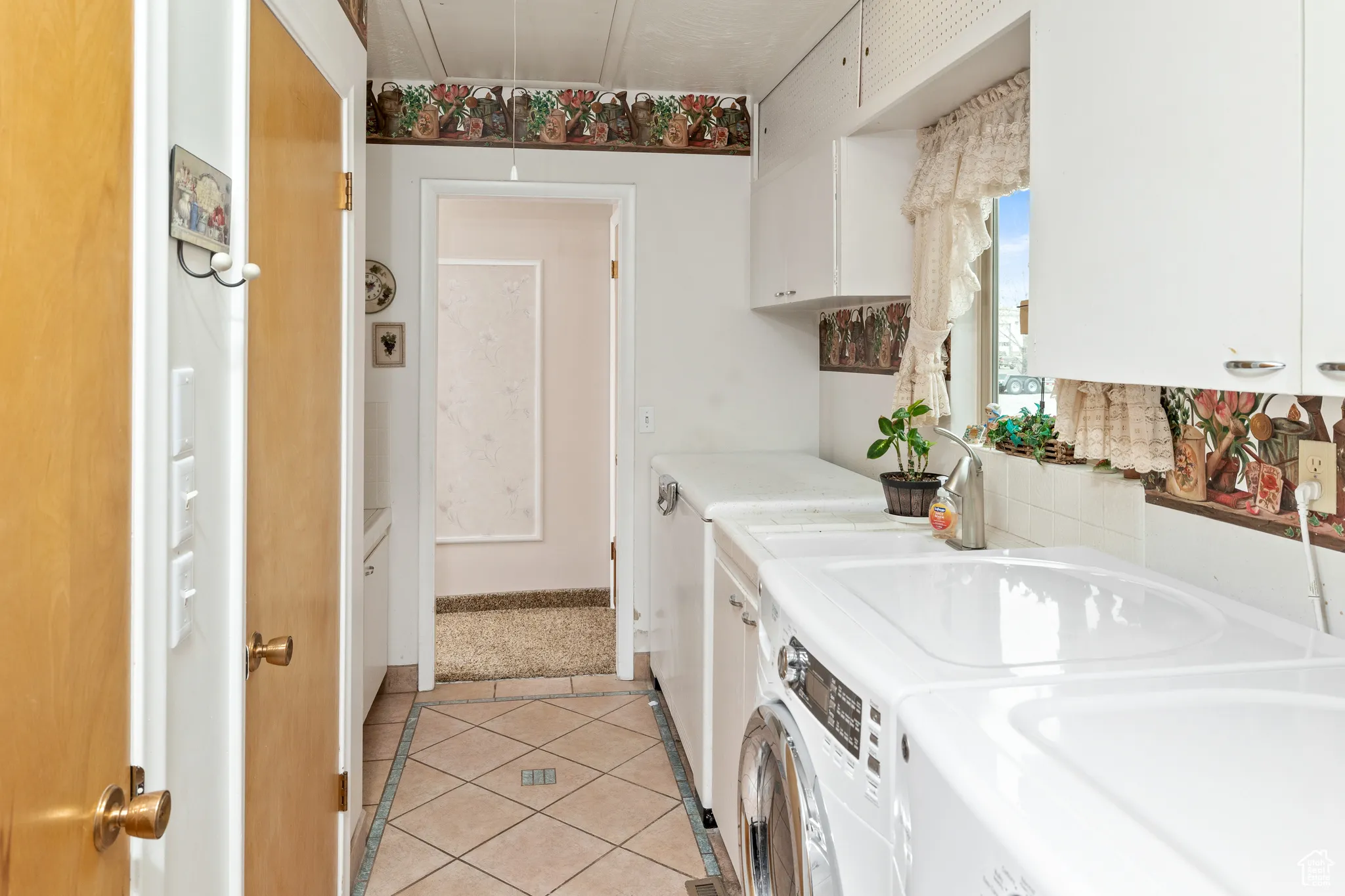 Laundry area featuring washer and clothes dryer, attic access, light tile patterned floors, and baseboards