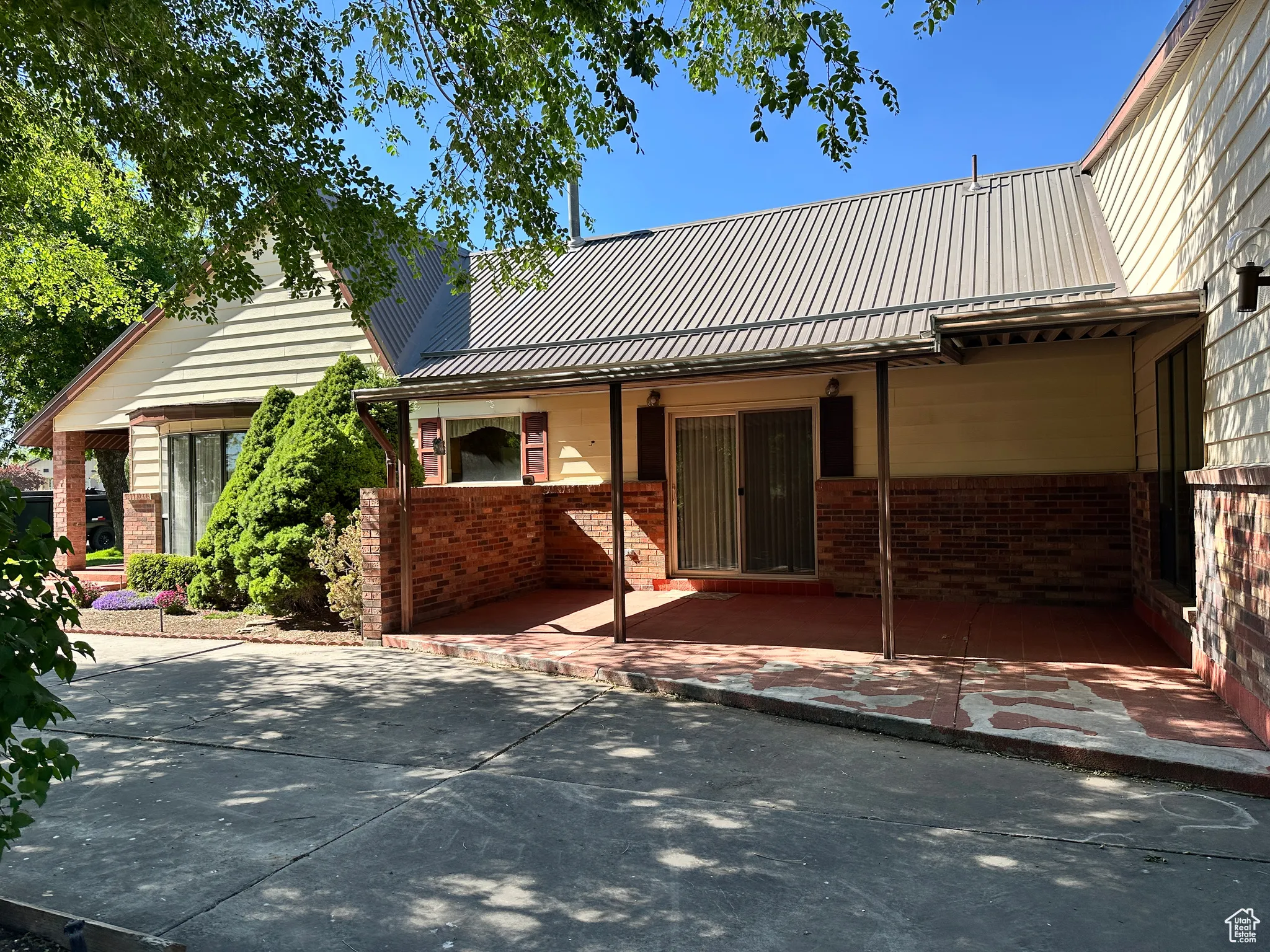 View of front of property with brick siding and metal roof