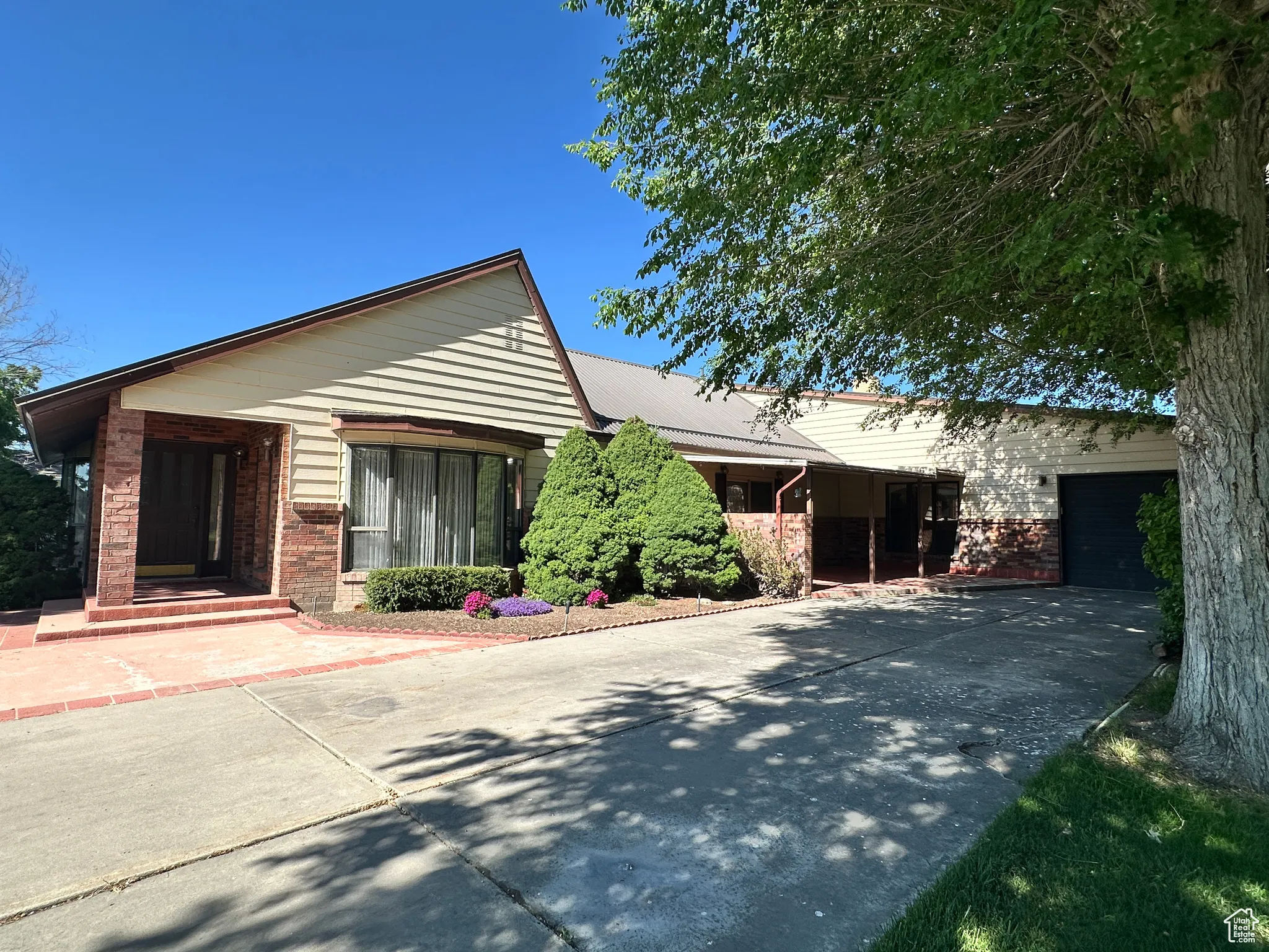 Ranch-style home with concrete driveway and brick siding