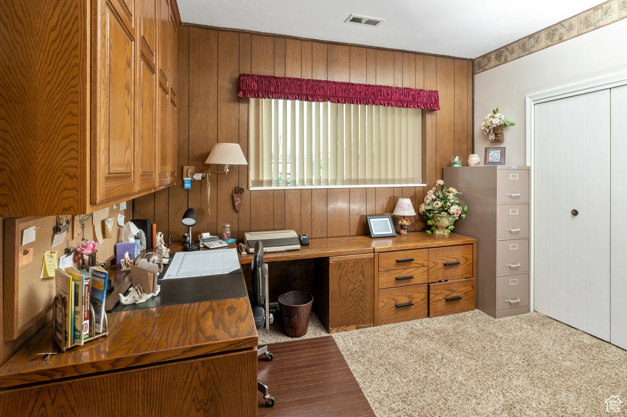 Office space with wood walls and carpet flooring