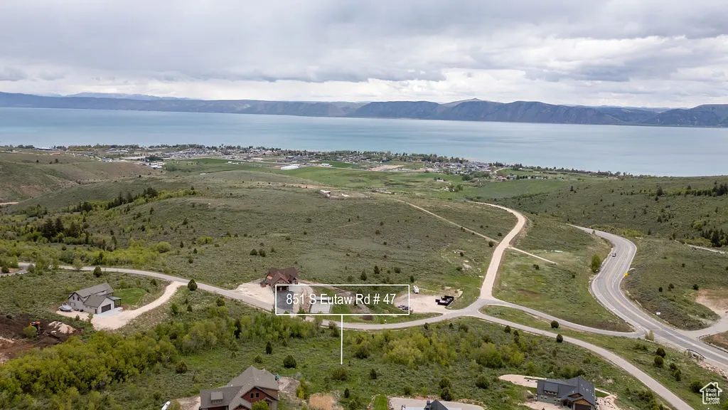 Aerial view of property and surrounding area with a water and mountain view