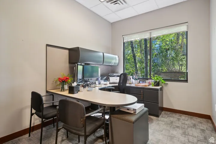 Office area featuring baseboards and a paneled ceiling