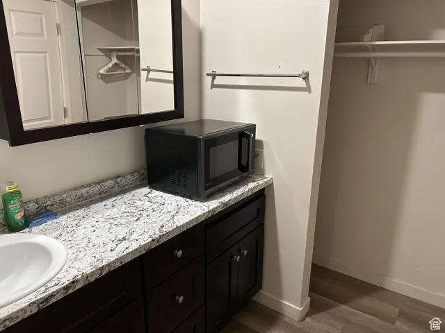 Bathroom with wood finished floors, vanity, and baseboards