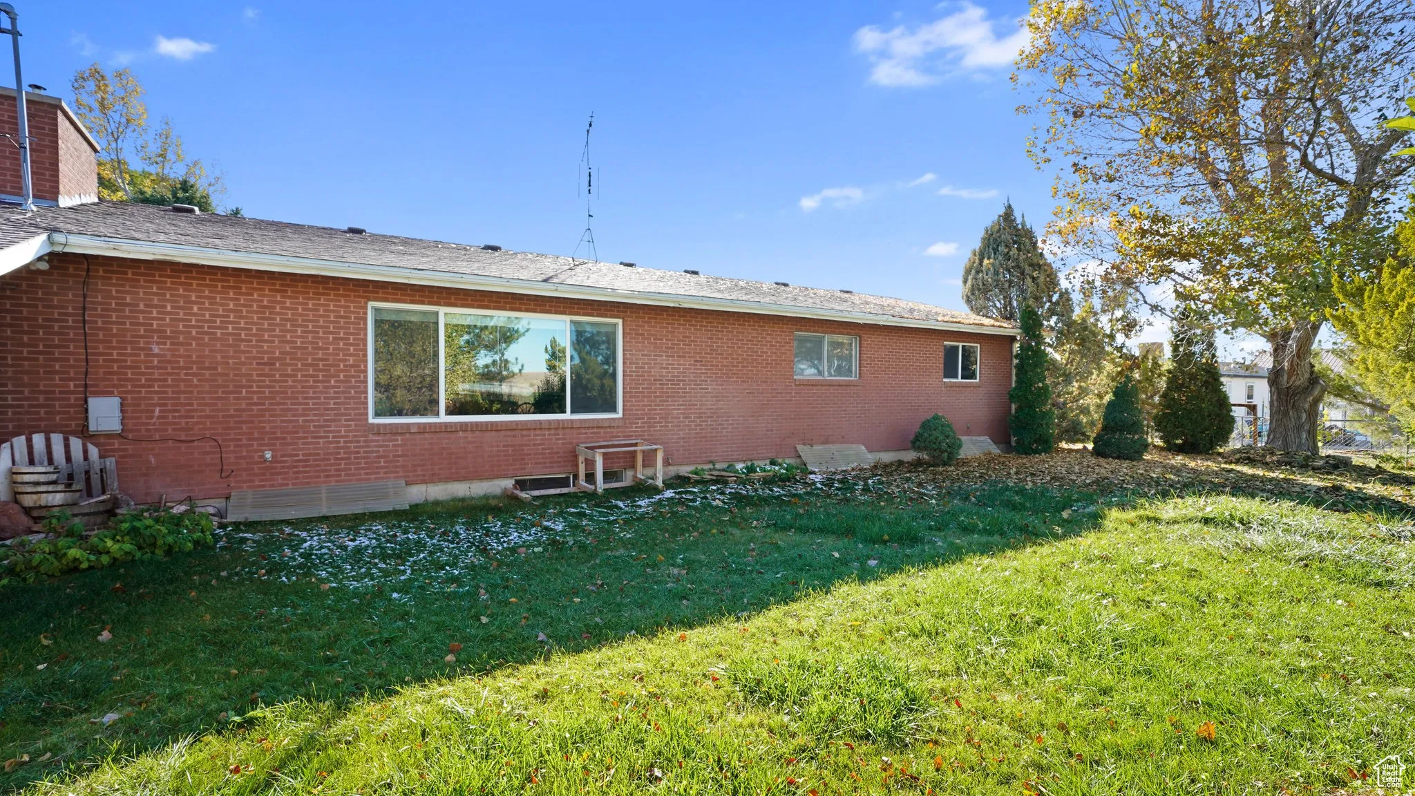 Back of house with brick siding and a lawn