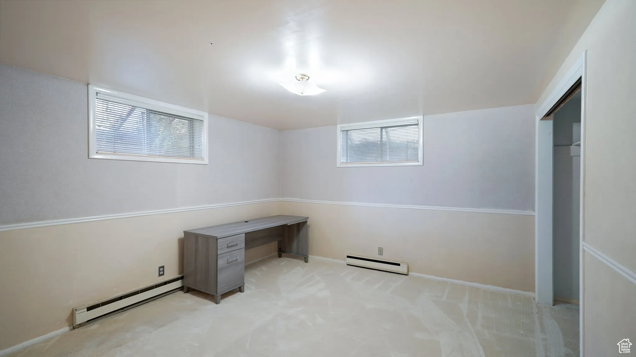 Unfurnished office featuring baseboard heating, carpet flooring, and baseboards