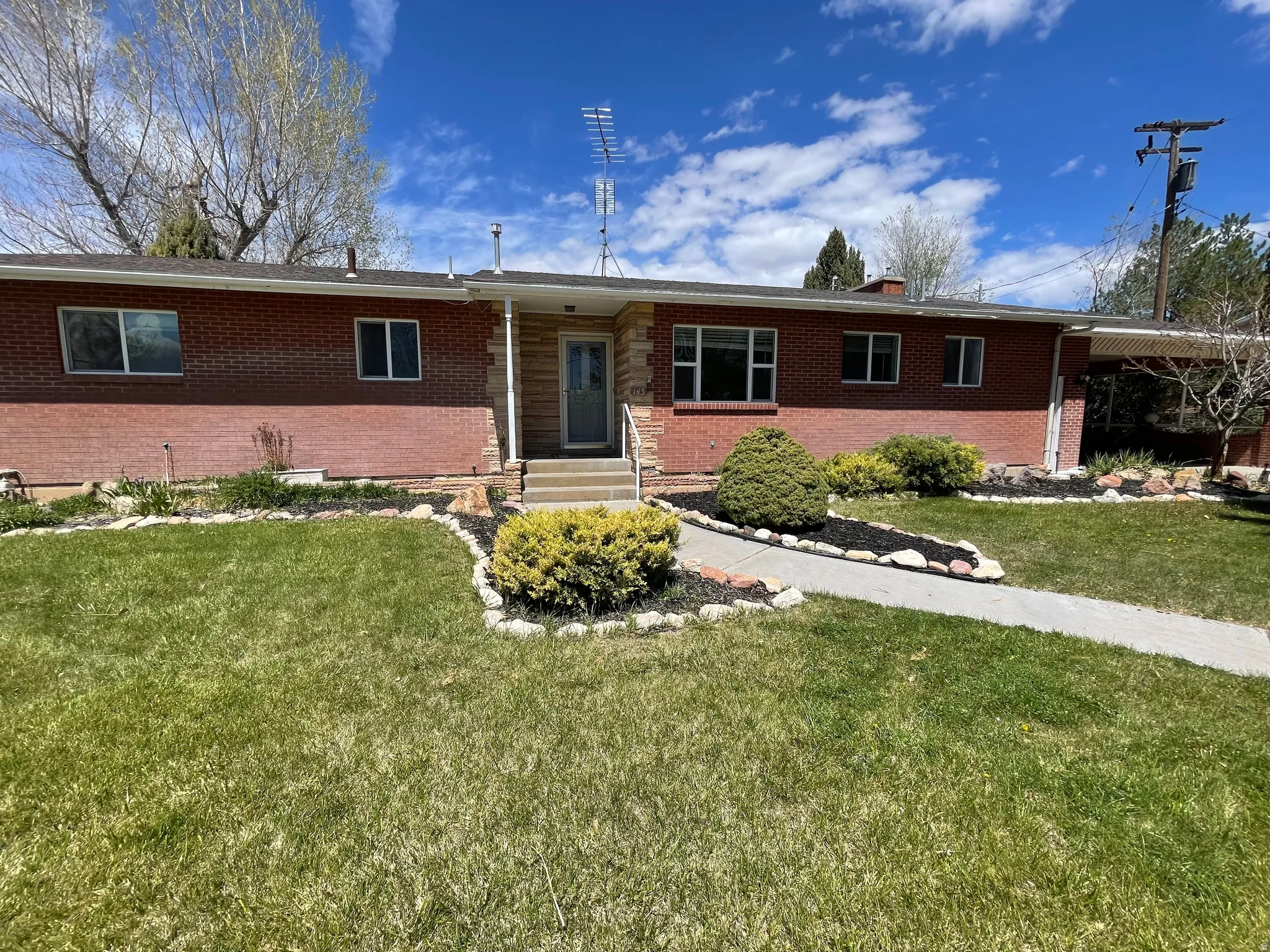 Ranch-style home featuring brick siding and a front lawn
