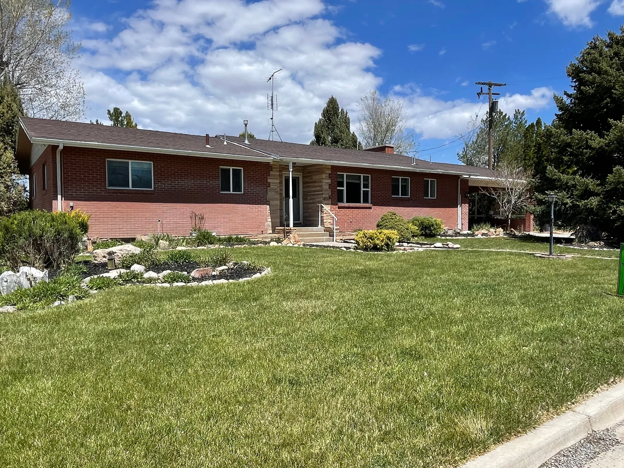 Ranch-style house with brick siding, a front yard, and a chimney