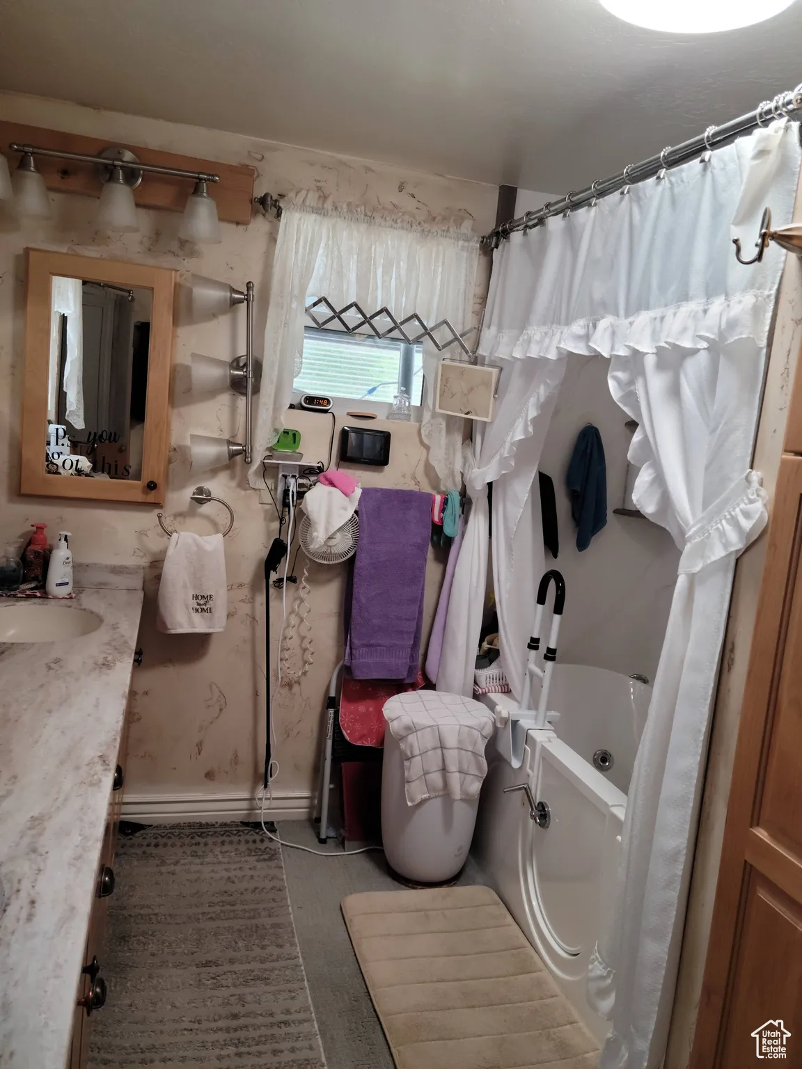 Bathroom featuring vanity, a tub to relax in, and a shower with shower curtain