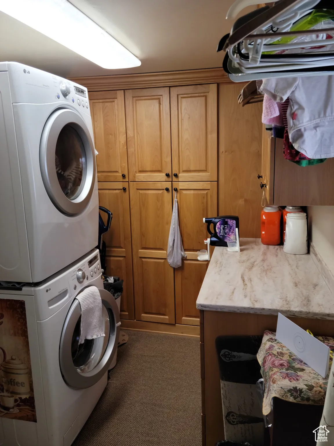 Laundry area featuring stacked washer and clothes dryer, and cabinet space