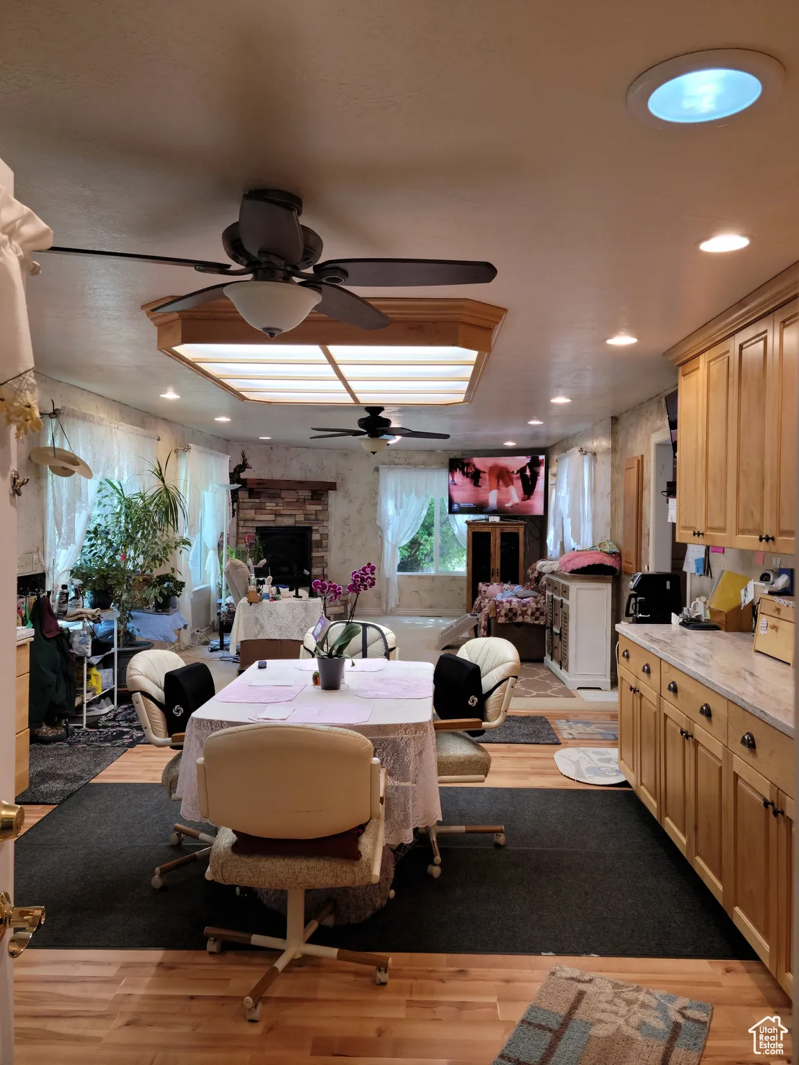 Dining space featuring a fireplace, a ceiling fan, light wood-type flooring, and recessed lighting