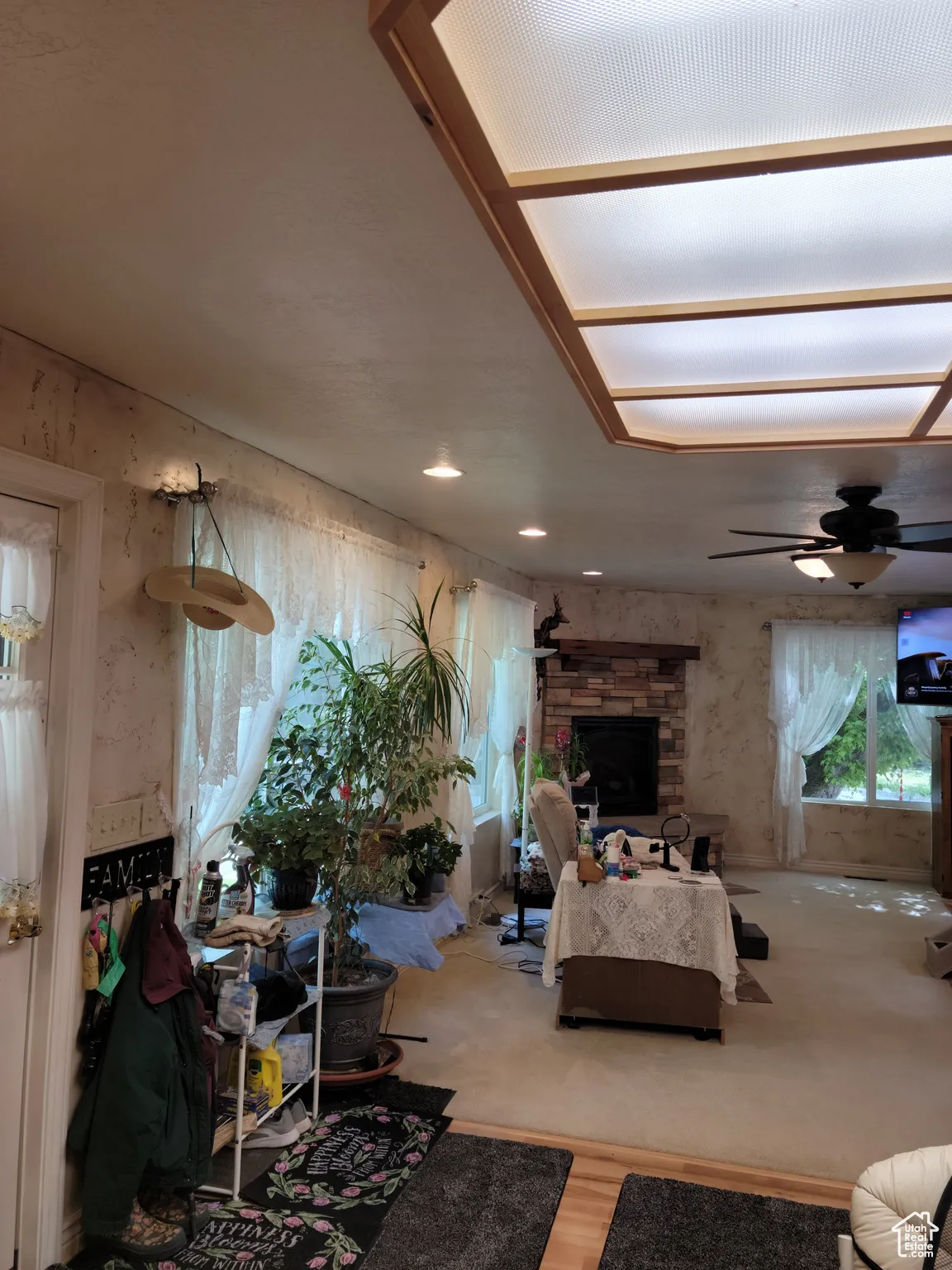 Living room with ceiling fan, a fireplace, and wood finished floors