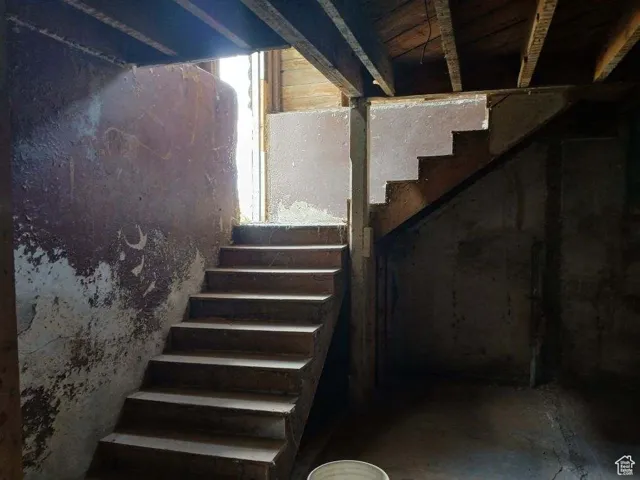 Staircase featuring unfinished concrete floors
