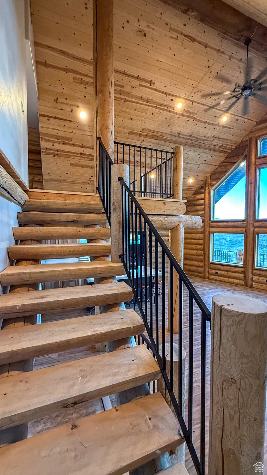 Stairway featuring log walls, wood ceiling, recessed lighting, a ceiling fan, and high vaulted ceiling