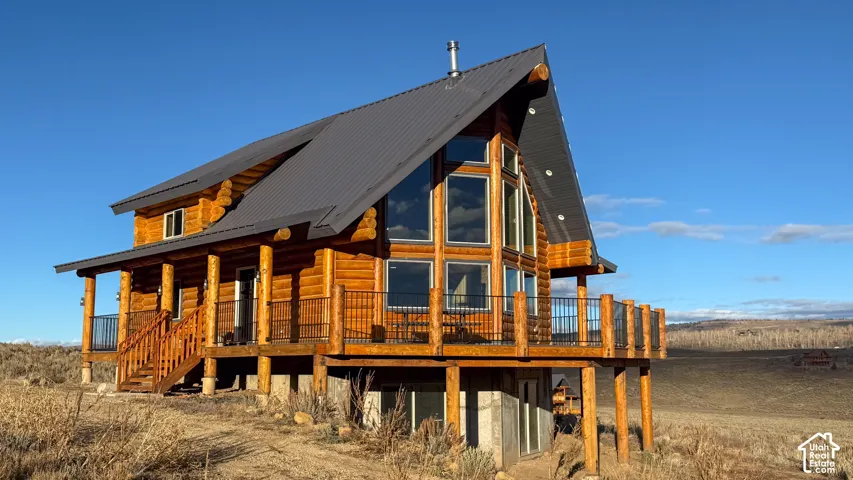 Rear view of house featuring a metal roof and a porch