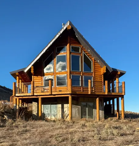 View of side of home featuring a wooden deck and log siding