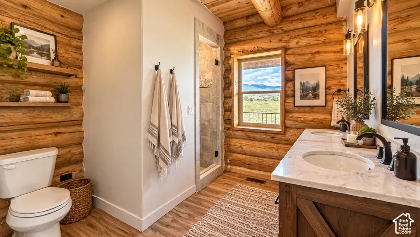 Log wall accents, double vanity with stone countertops, wood-finish flooring, built-in shelving, and a large window