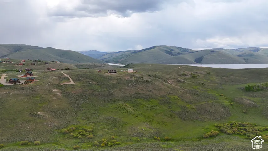 View of mountain backdrop with a nearby body of water and rural landscape