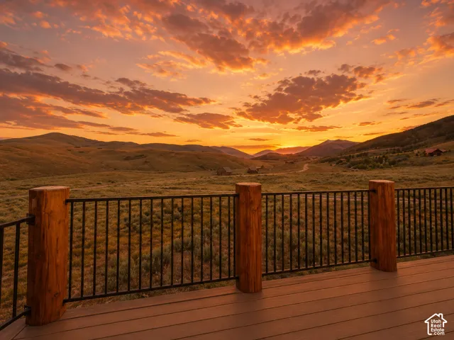 Spacious outdoor deck featuring wood-finish flooring, sturdy log posts, and dark metal railings