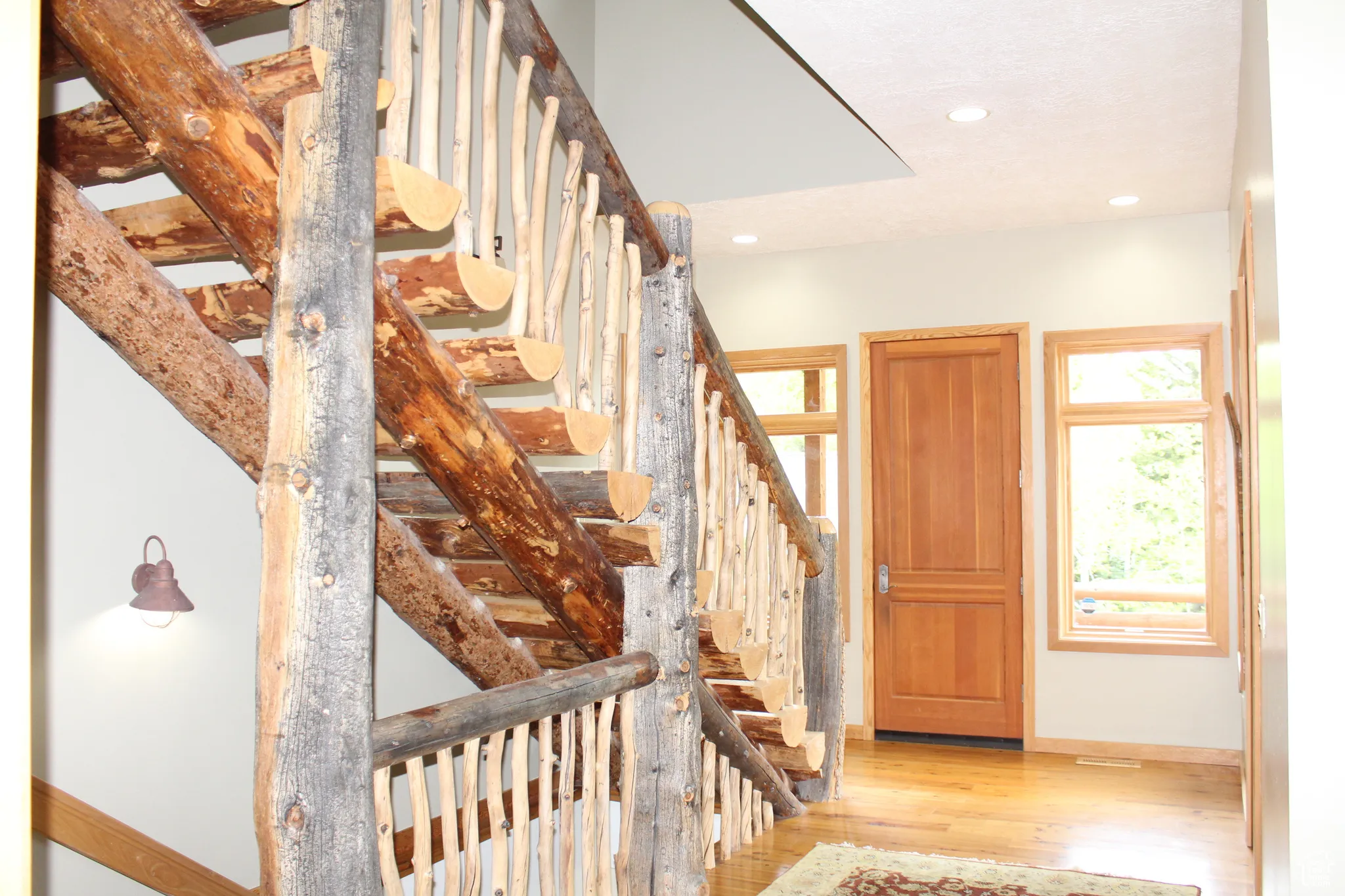 Foyer with light wood-style flooring, baseboards, stairs, and recessed lighting