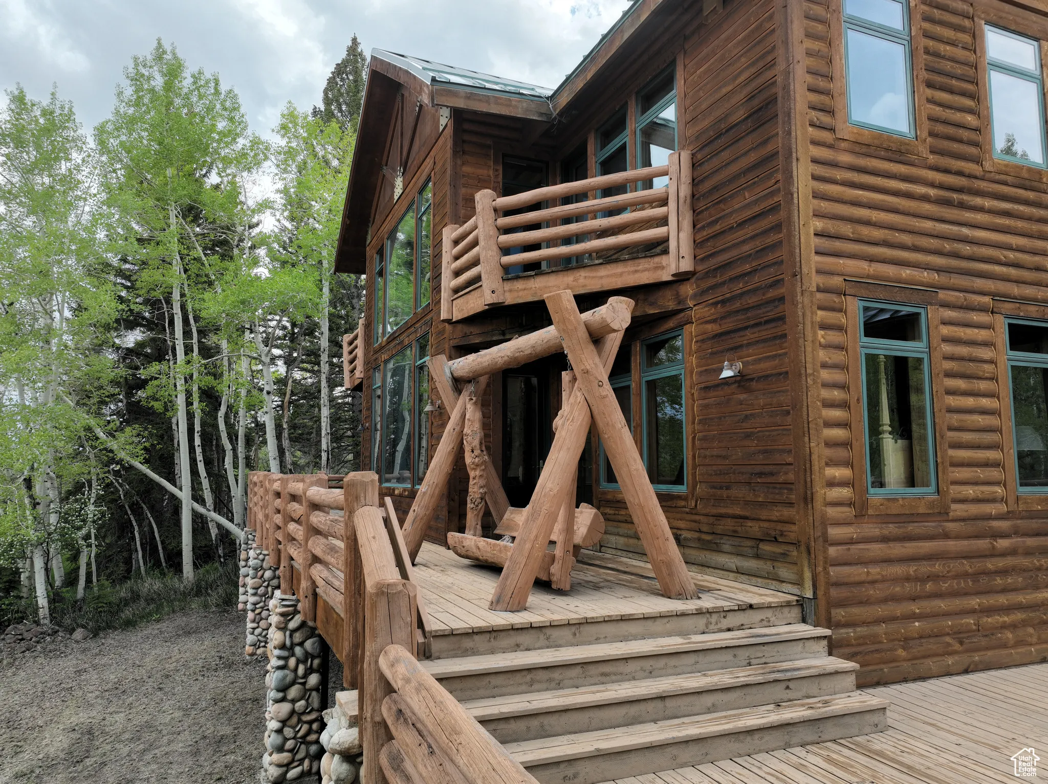 View of side of home featuring log veneer siding and a deck