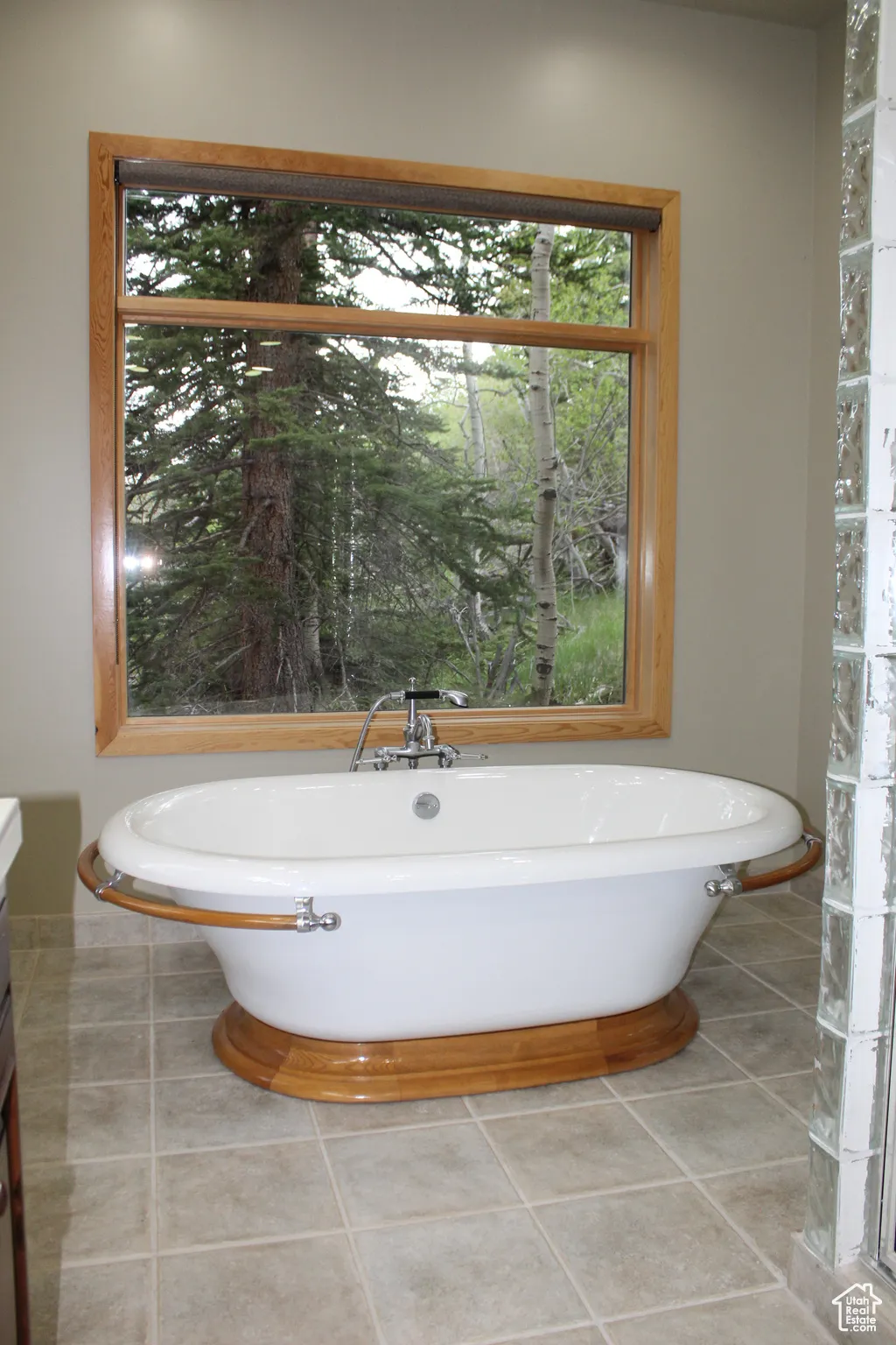 Bathroom featuring a freestanding bath, tile patterned flooring, vanity, and baseboards