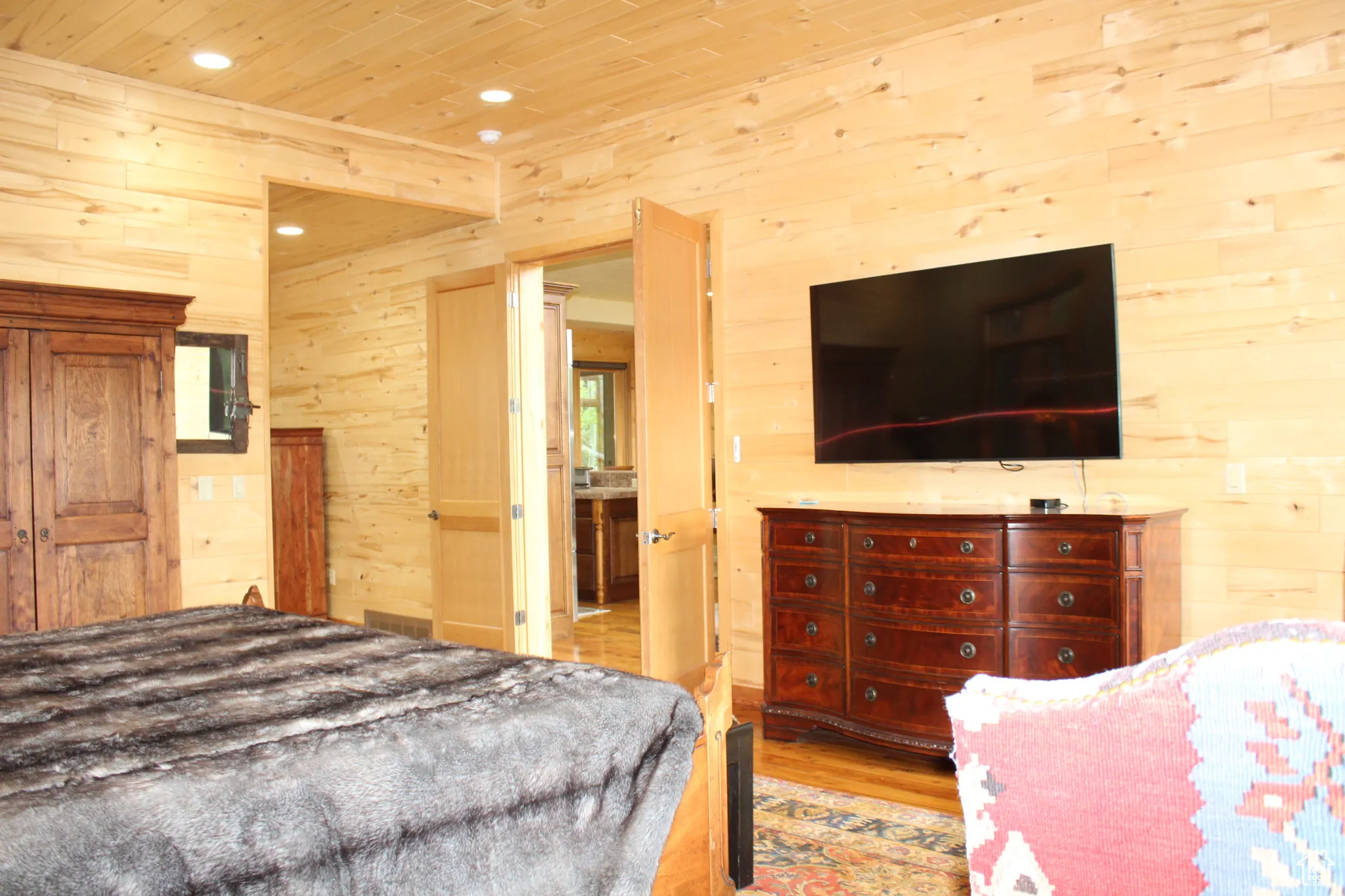 Bedroom with wooden walls, recessed lighting, light wood-style floors, and wooden ceiling