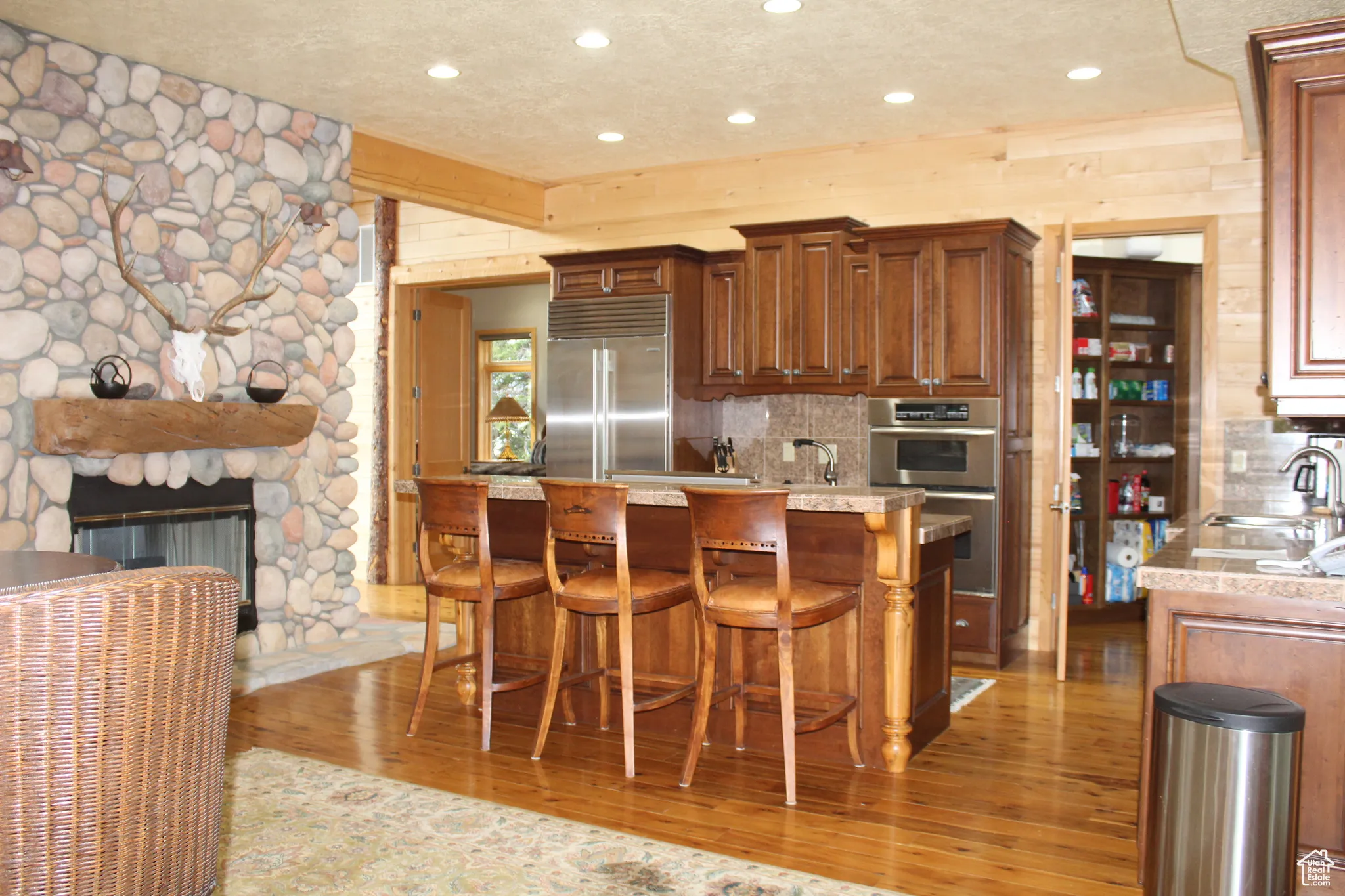 Kitchen with stainless steel appliances, light wood-style floors, a sink, tasteful backsplash, and recessed lighting