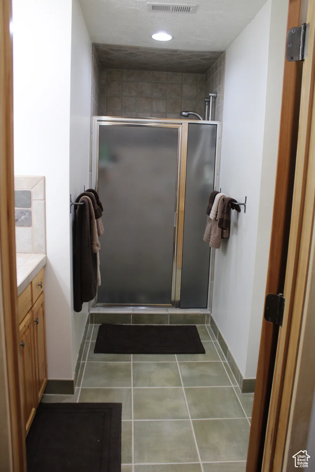 Full bathroom with vanity, a shower stall, baseboards, tile patterned floors, and recessed lighting