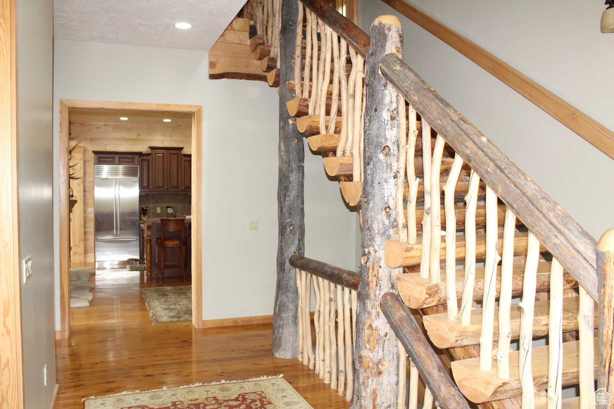 Staircase with wood finished floors, baseboards, and recessed lighting