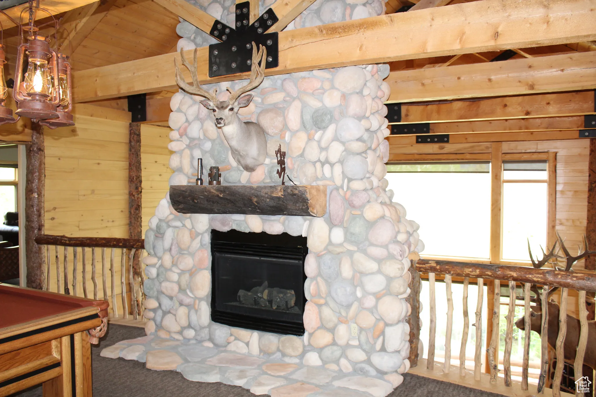 Living room with wood walls, carpet flooring, a fireplace, and billiards table