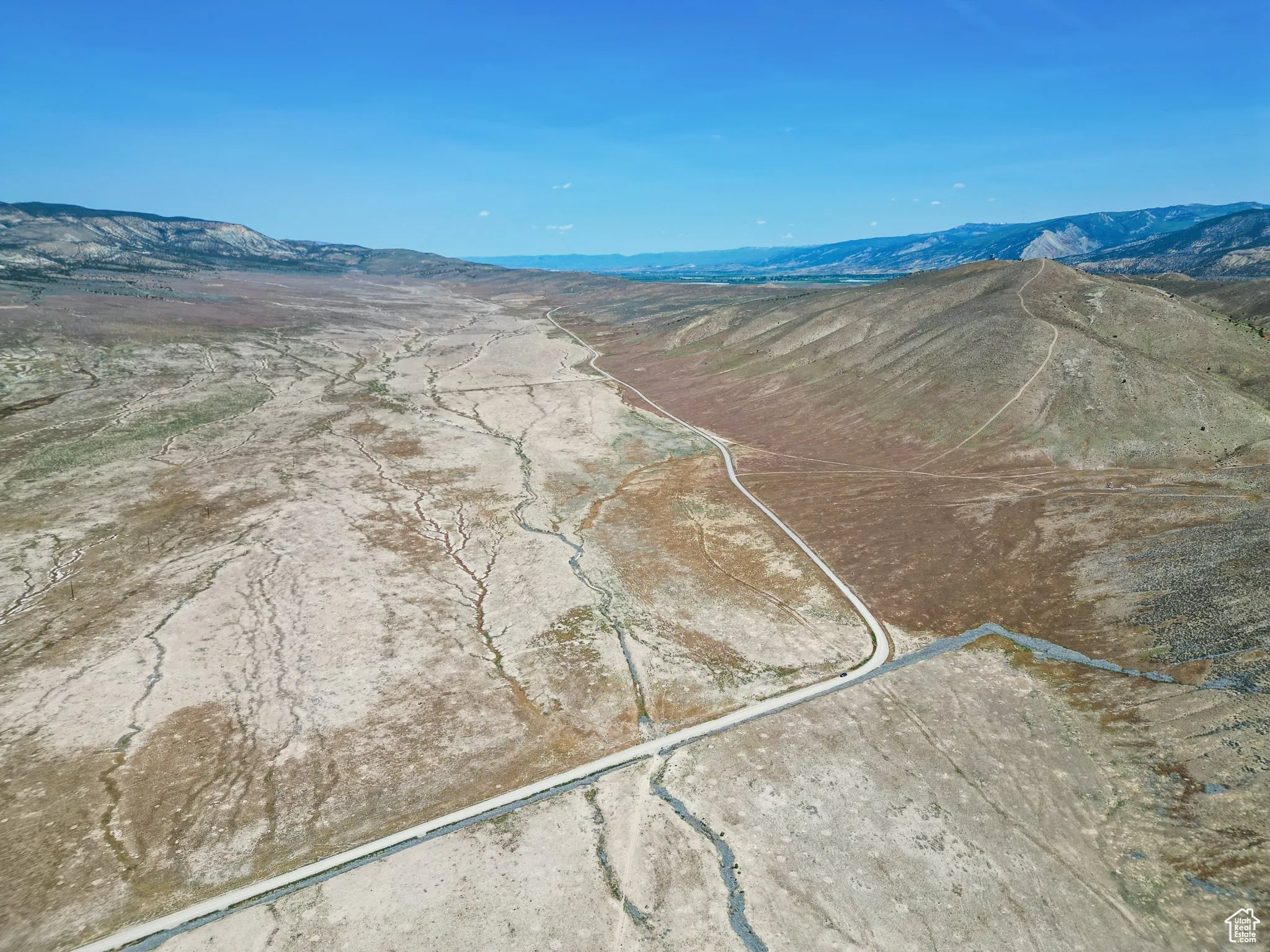 Aerial overview of property's location with a mountainous background and property boundaries highlighted