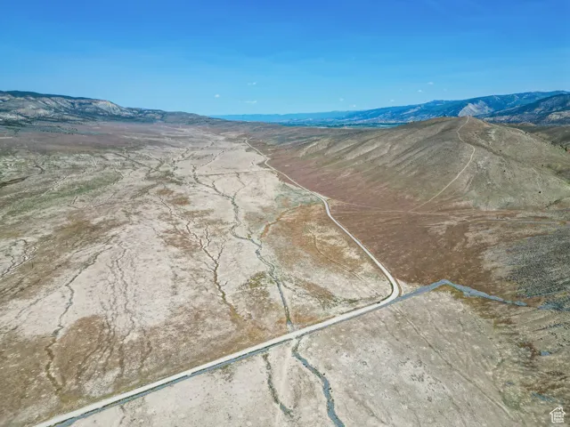 Aerial overview of property's location with a mountainous background and property boundaries highlighted