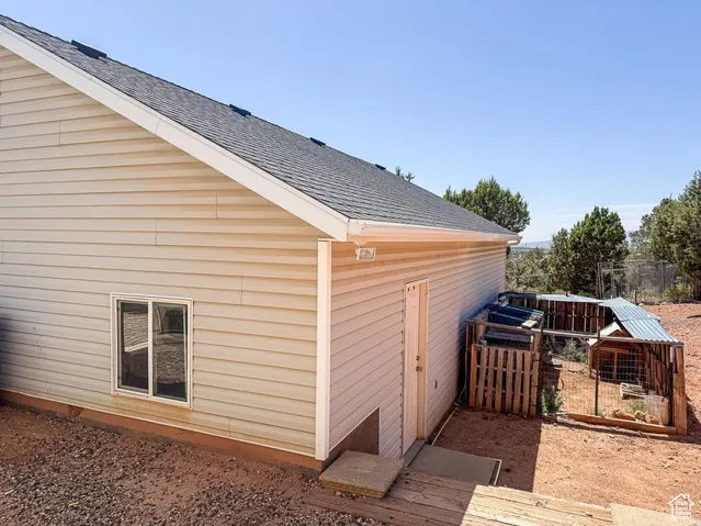 View of side of home featuring roof with shingles
