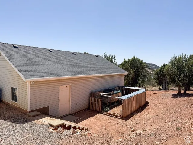 Rear view of property featuring a shingled roof and a mountain view