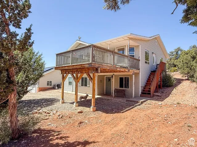 Rear view of property with a deck and stairway