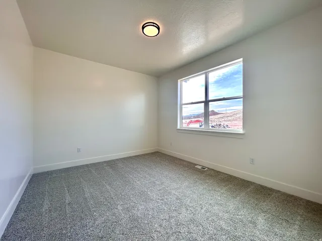 Empty room featuring carpet flooring and a textured ceiling