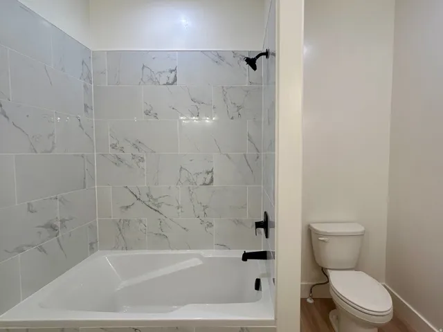 Bathroom with toilet and tiled shower / bath