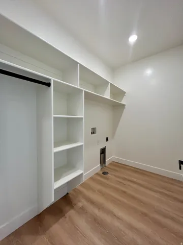 Washroom with hookup for a washing machine, recessed lighting, electric dryer hookup, and light wood-style flooring