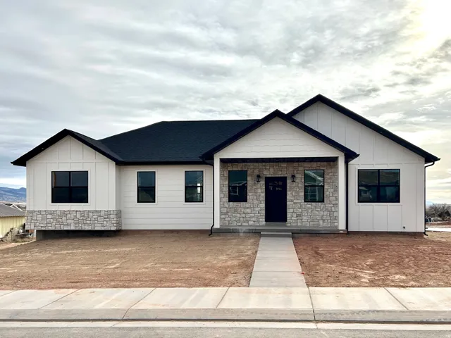 Modern farmhouse with covered porch, stone siding, and board and batten siding