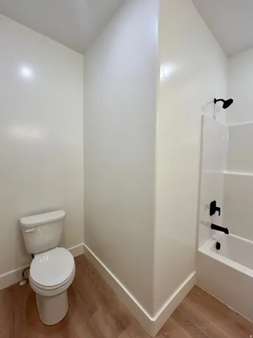 Bathroom featuring tub / shower combination and light wood finished floors