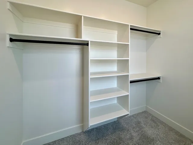 Walk in closet featuring dark colored carpet