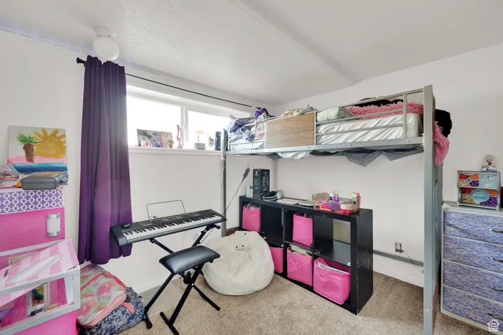 Bedroom featuring carpet, baseboards, and a textured ceiling