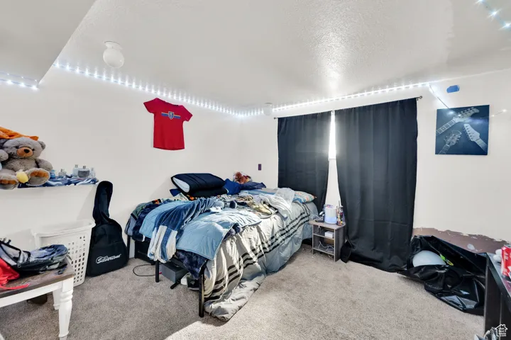 Carpeted bedroom with a textured ceiling