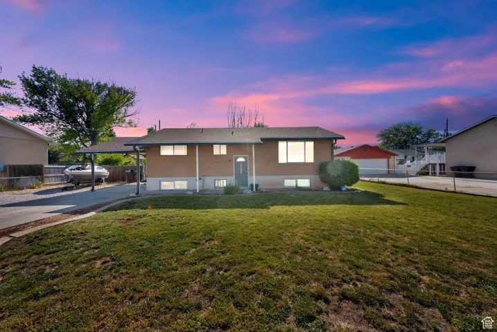 Split foyer home featuring concrete driveway and a carport