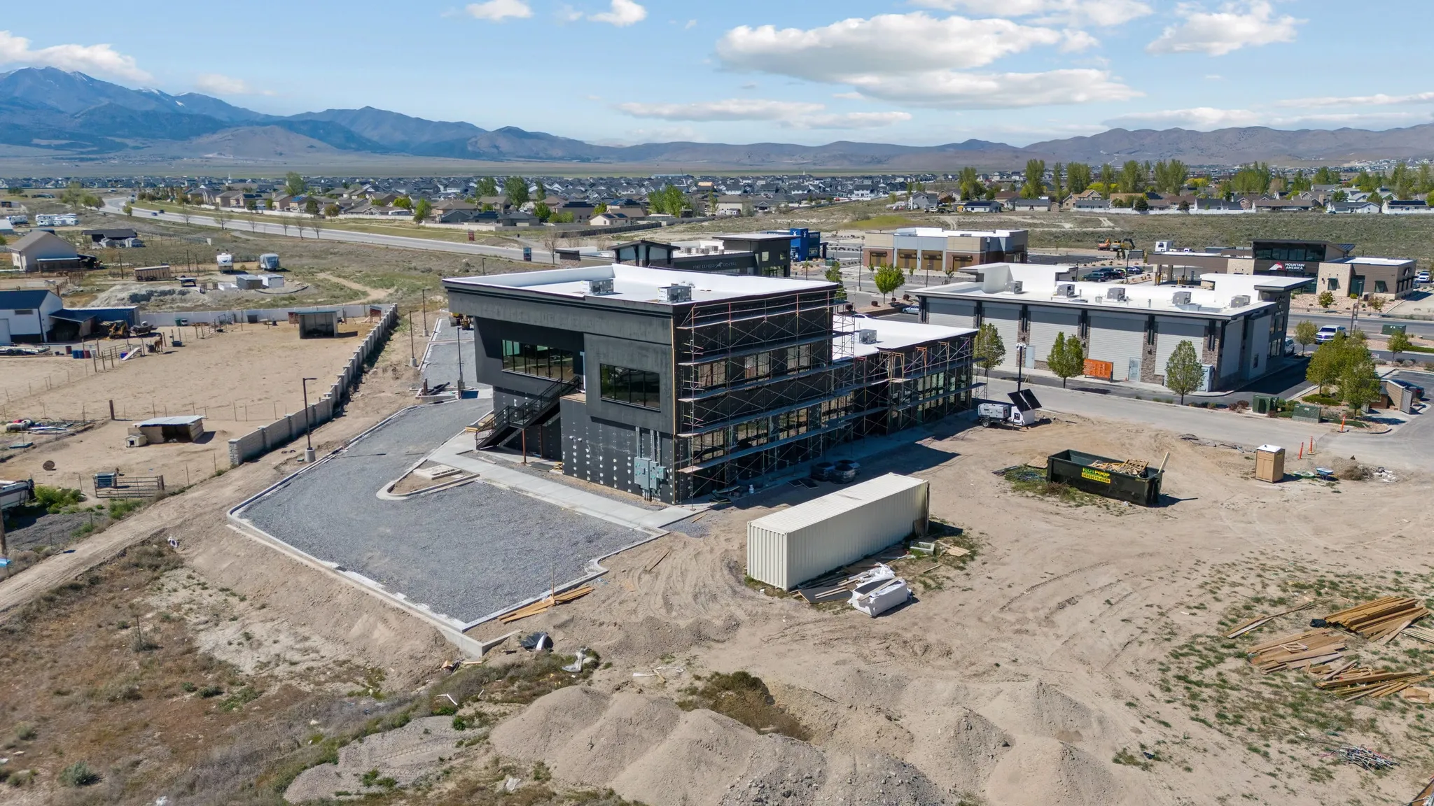 Modern commercial building featuring dark exterior cladding and extensive window lines