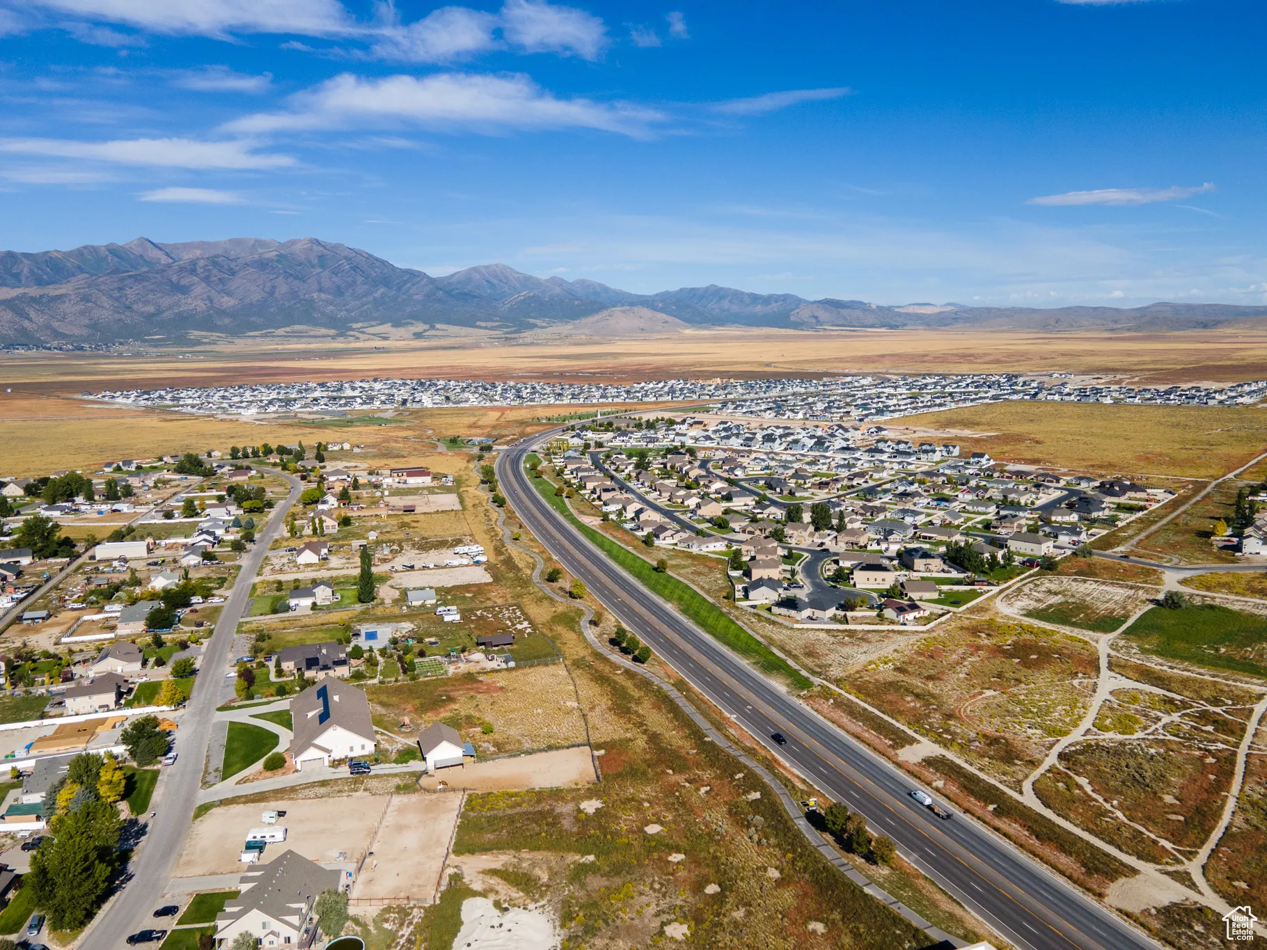 Aerial view of property's location with a mountainous background and nearby suburban area