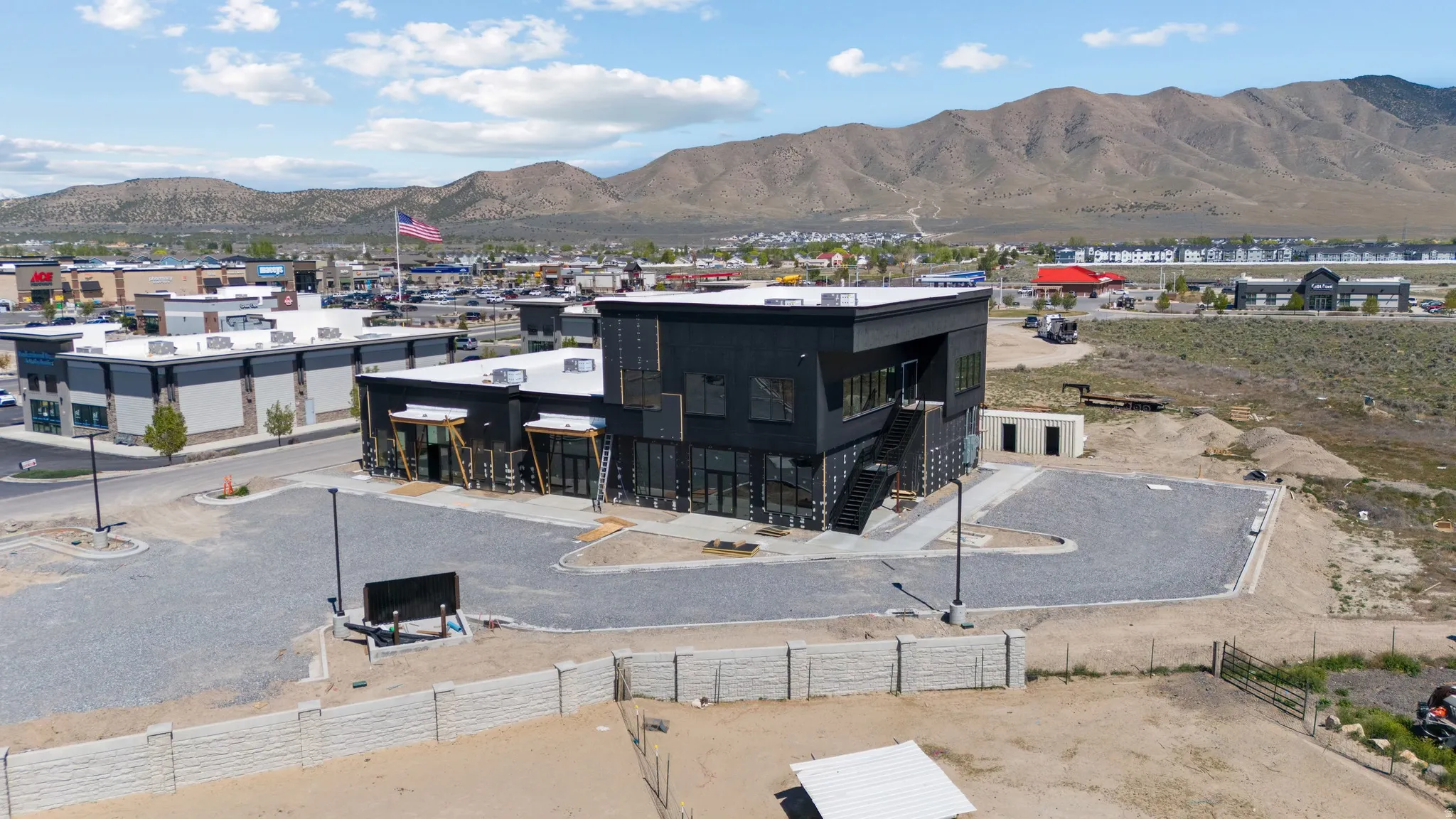 Modern commercial building featuring dark exterior cladding and extensive window lines