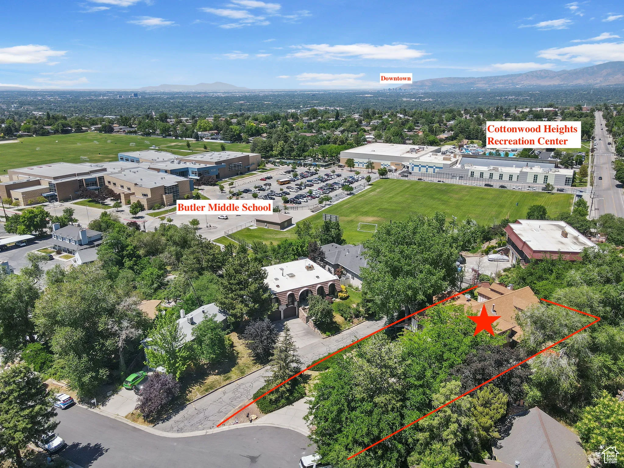 Aerial overview of property's location with property boundaries highlighted and a mountainous background