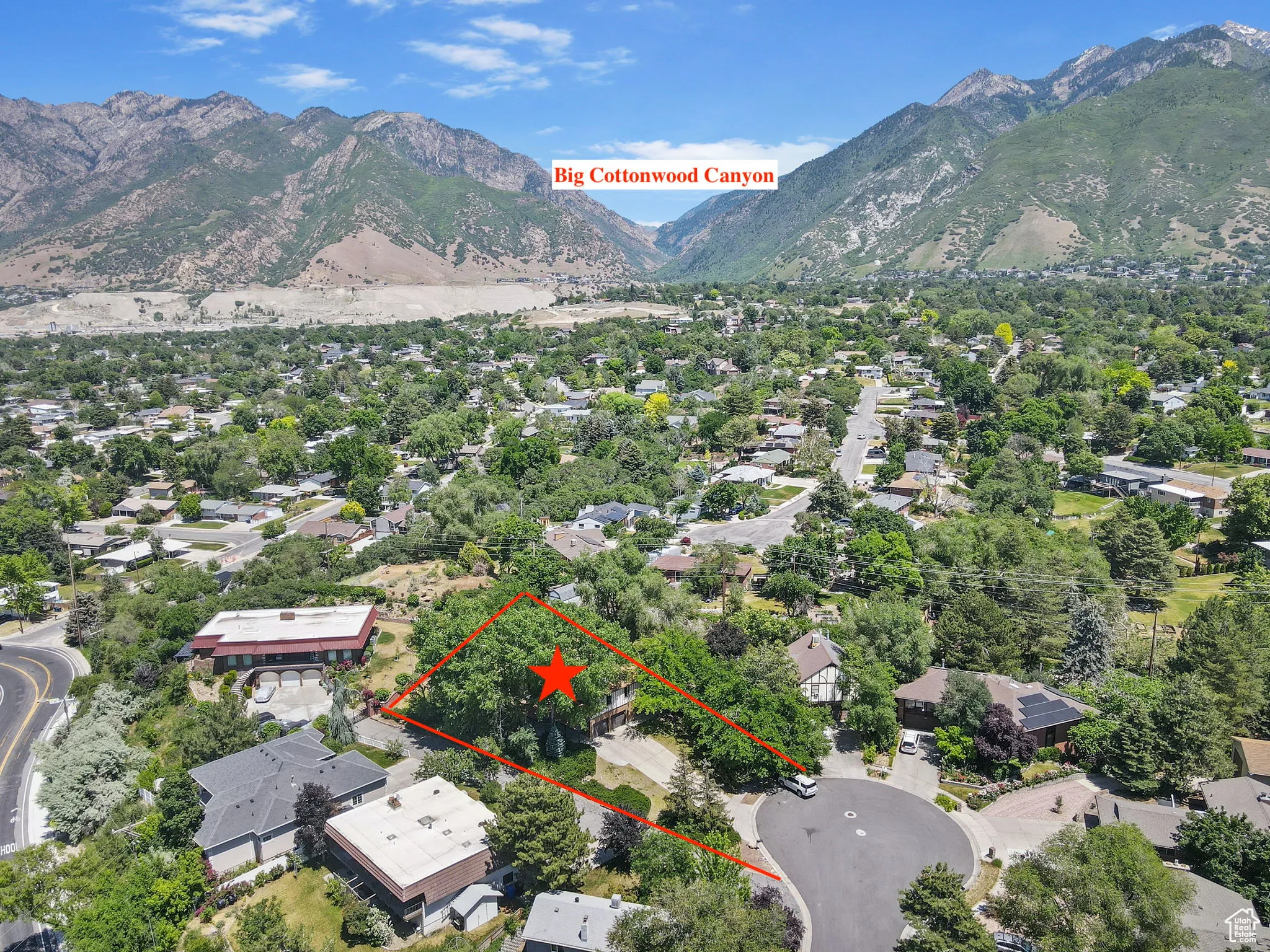Aerial perspective of suburban area featuring a mountain backdrop and property boundaries highlighted