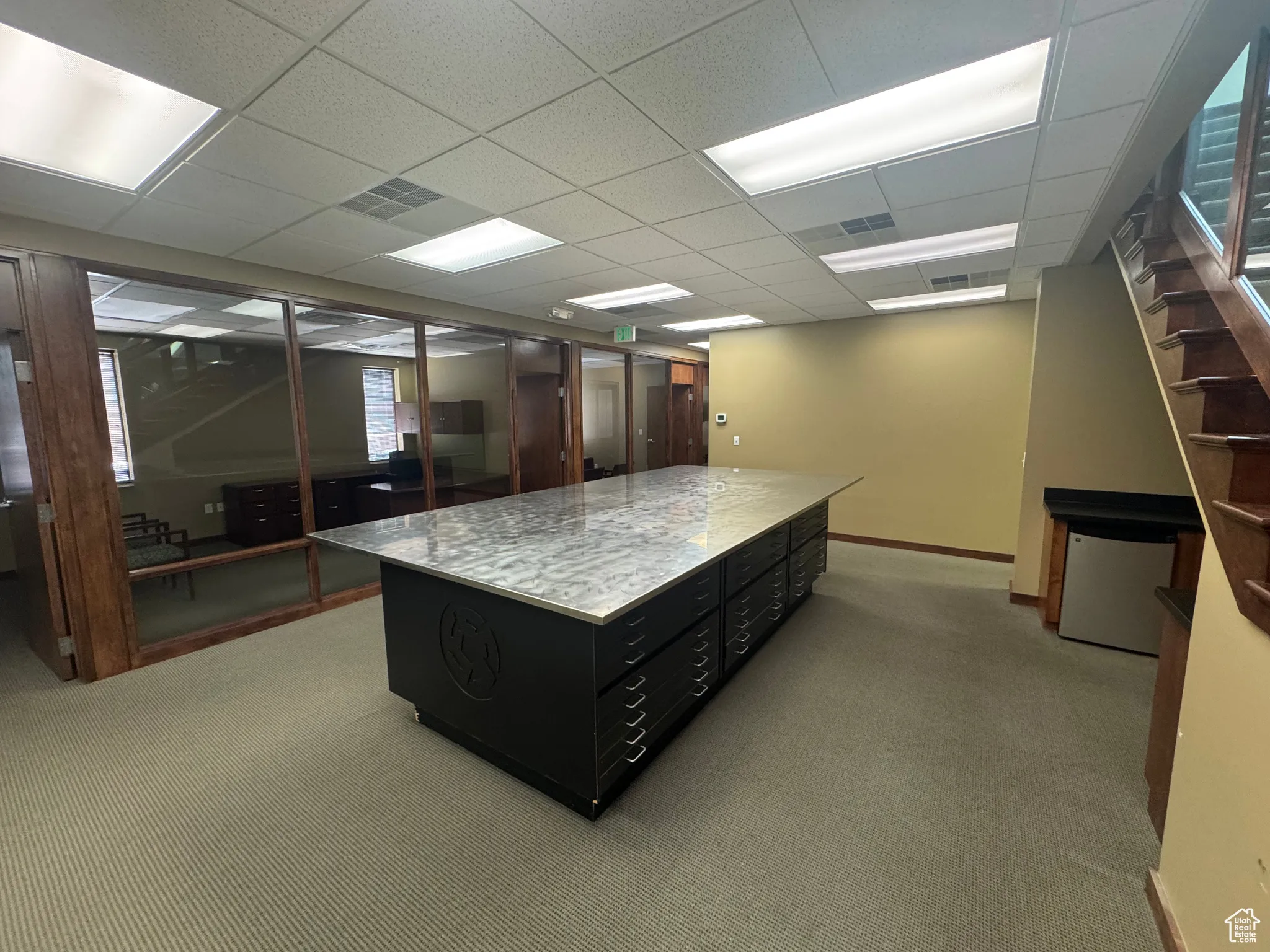 Home office featuring light colored carpet and a paneled ceiling